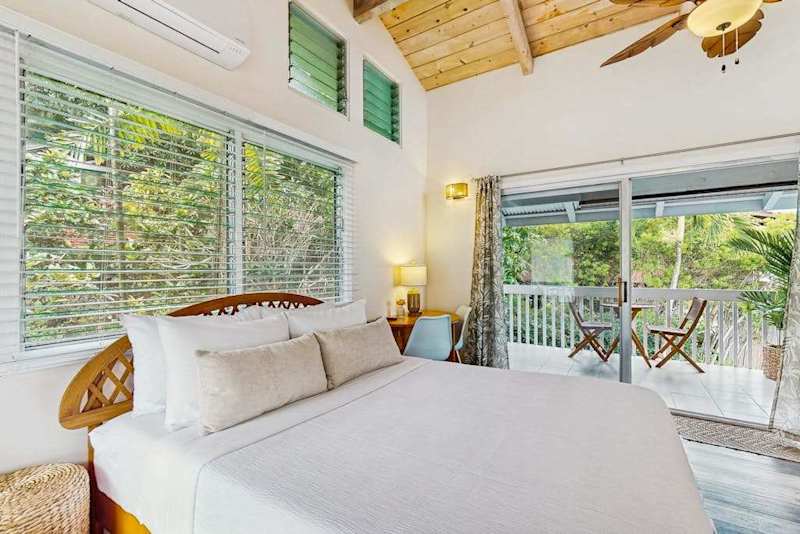 ​Cozy queen bedroom with wood-paneled high ceiling