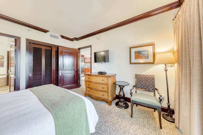 Second Bedroom Featuring Armchair Seating, Dresser & Wall TV