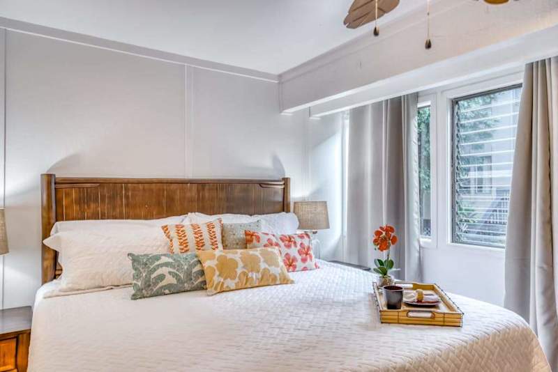 Sunlit Bedroom Retreat with Plush Bedding & Tropical Charm