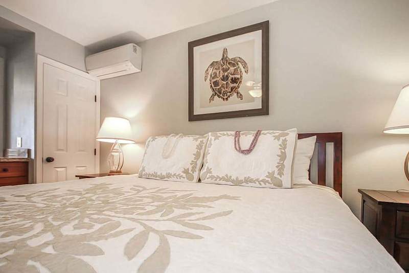 Master bathroom with king bed, flat screen tv and a ceiling fan.