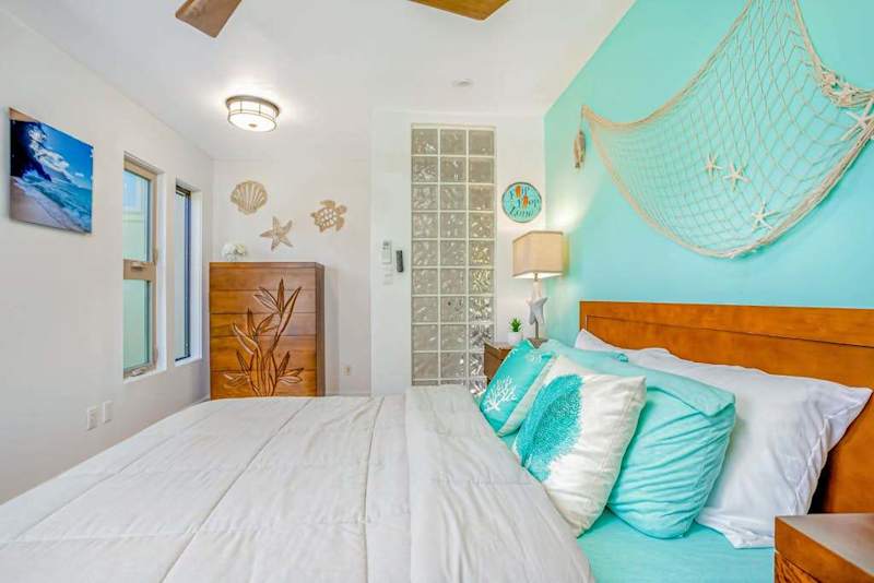 Guest bedroom with queen bed and ceiling fan.
