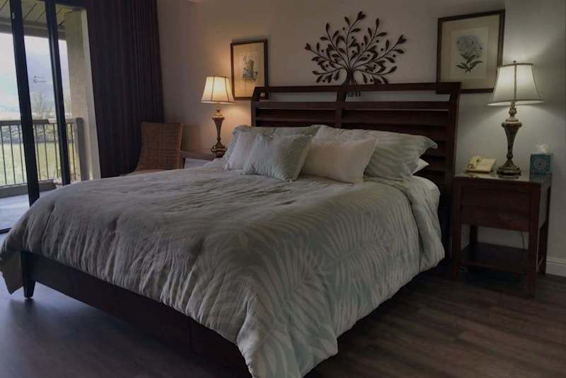 Primary bedroom showcases king bed, bedside tables, and warm lighting