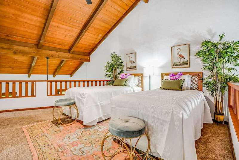 Two twin beds located in the loft with vaulted ceilings.