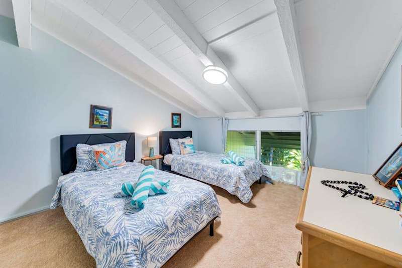 Guest room lofted ceilings and two twin beds.