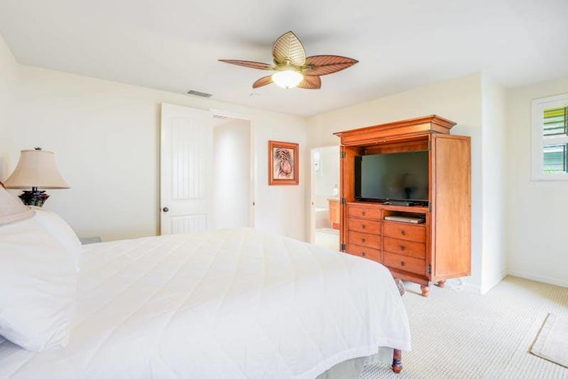 Guest bedroom with flat screen tv and a queen bed.