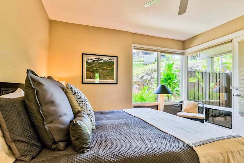 Master bedroom with king bed, flat screen tv and large windows for tropical views and private lanai access.