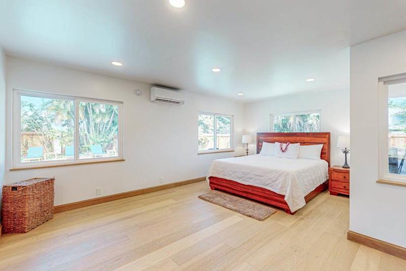 First Bedroom features crisp linens warm wood floors and garden light