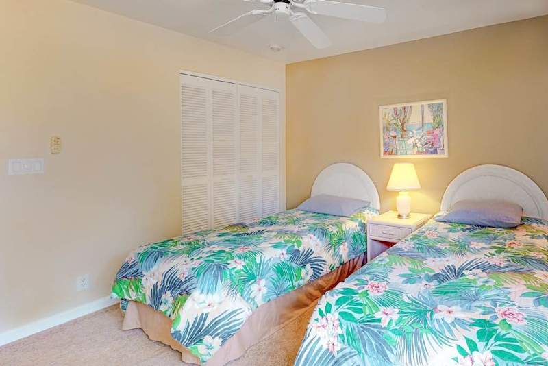 Second bedroom offers twin beds ceiling fan and convenient storage