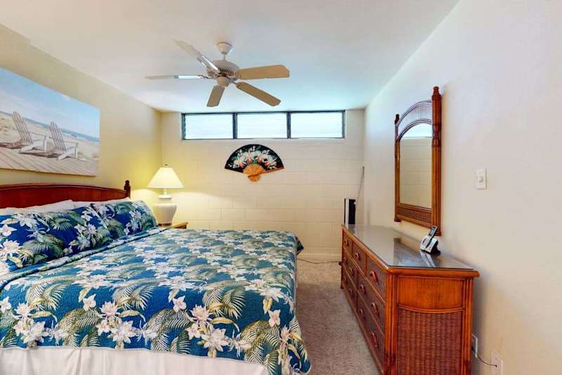 Spacious Primary Bedroom with Wooden Dresser & Natural Light