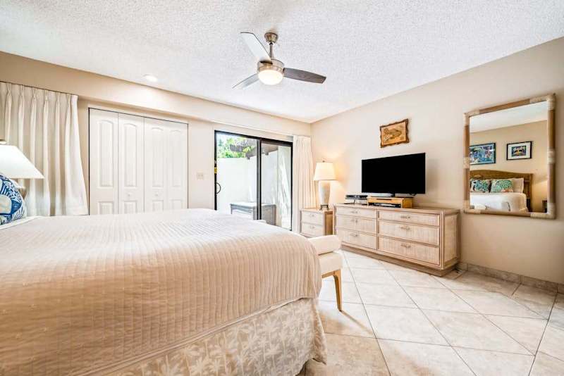 Bedroom features king bed ceiling fan dresser and views