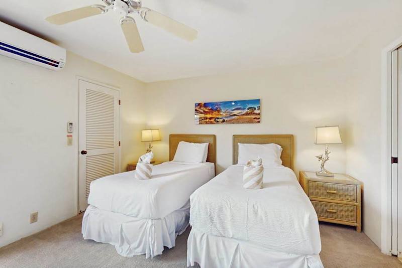 Second Bedroom twin beds rest beneath ceiling fan and artwork