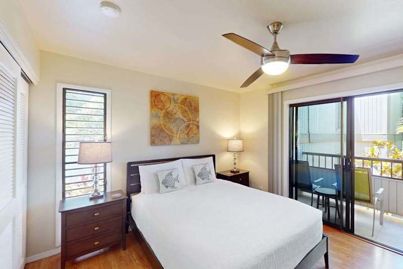 Cozy Bedroom Featuring Queen Bed, Ceiling Fan, and Sliding Glass Balcony Door