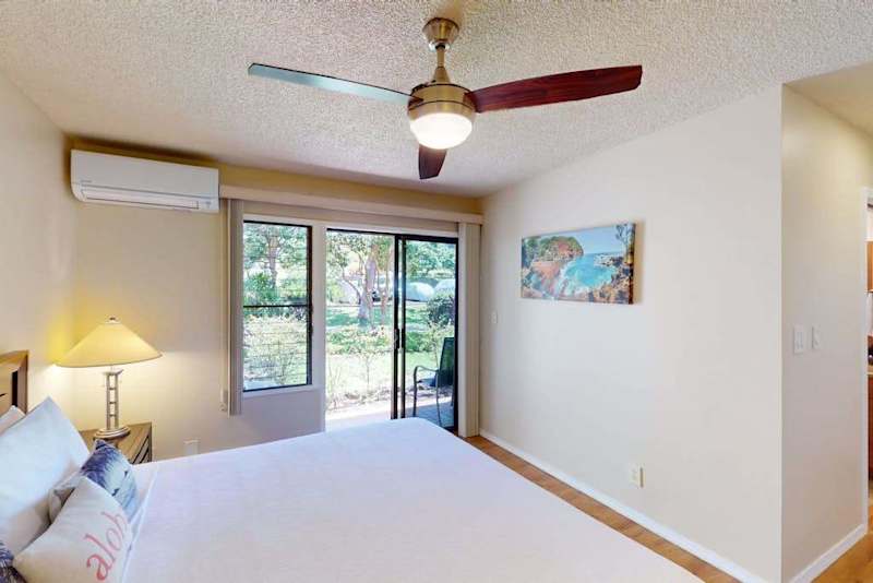 Bright Bedroom with King Bed, Split AC Unit, Ceiling Fan, and Patio Access