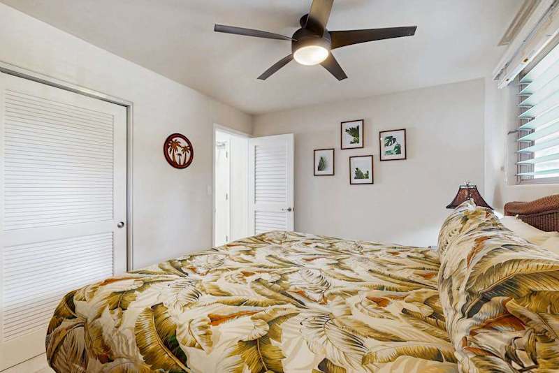 First bedroom offers king bed floral quilt tables and sunlight