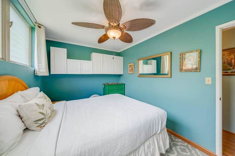 Inviting bedroom features a ceiling fan for refreshing comfort after island adventures daily