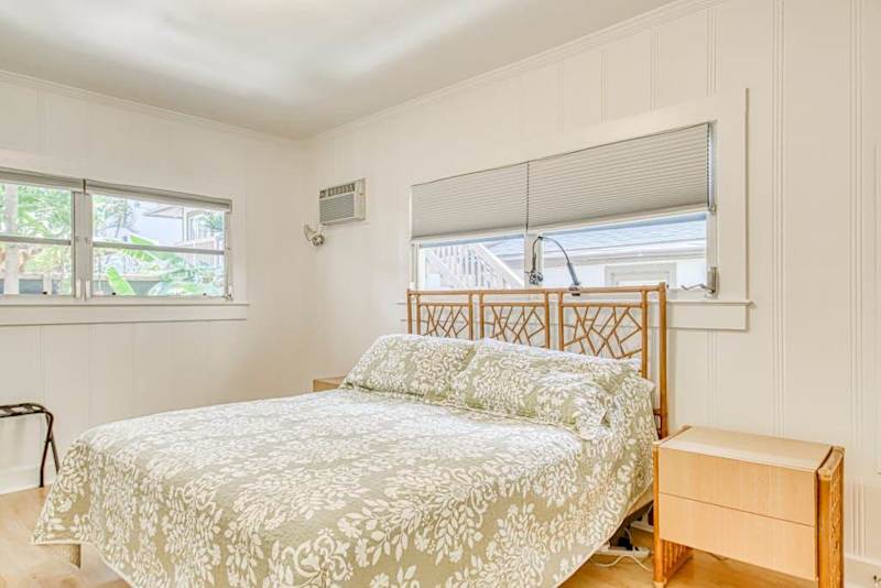 King bedroom features soft bedding and bright corner windows
