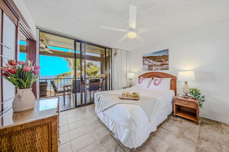 Bright bedroom layout featuring a comfortable bed, ceiling fan, and direct balcony access. 🛏️