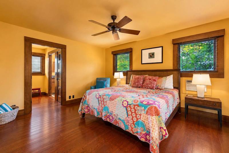 Wood-accented bedroom offers restful linens, bedside storage, and cheerful decor