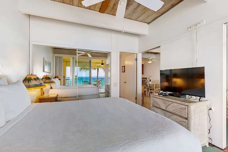 Spacious Bedroom with King Bed, Vaulted Wood Ceilings, Flat-Screen TV, and Mirrored Closet