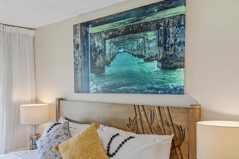 Bedroom wall artwork displayed directly above the bed