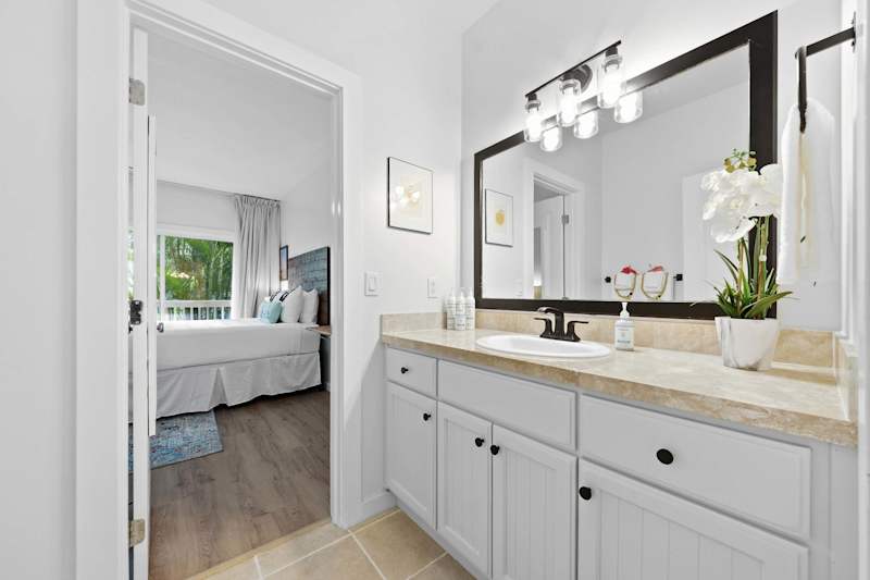 Bathroom Vanity with Lighted Mirror and View to Bedroom
