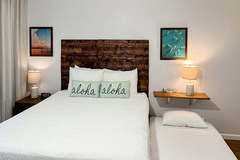 Bedroom with Rustic Wood Headboard and Aloha Pillows