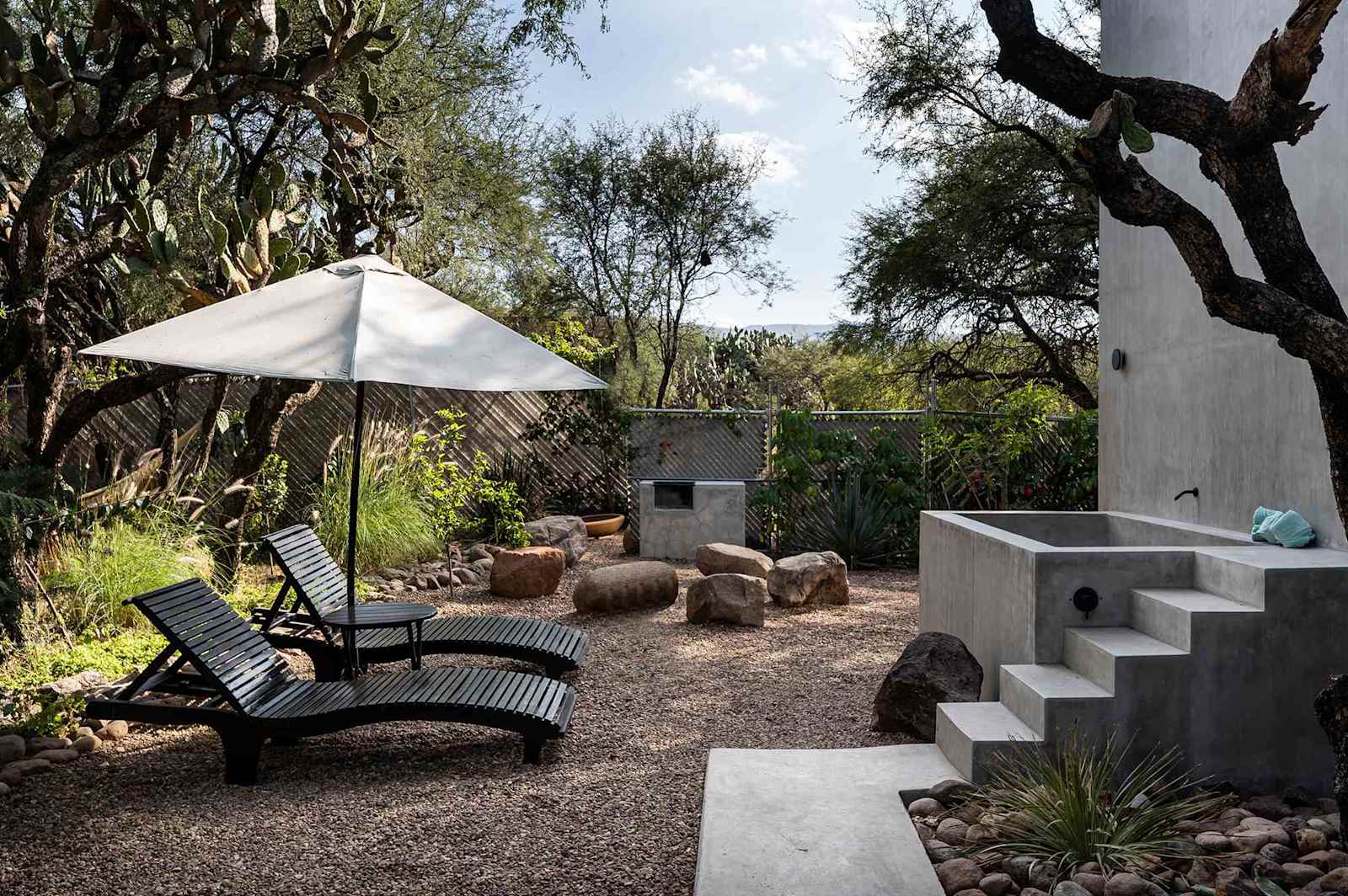 Lounge chairs and an oversized soaking tub sit outside.