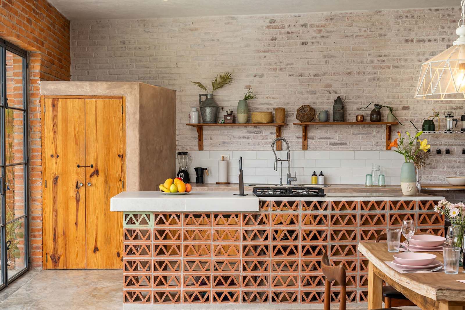 Fully equipped kitchen with wood cabinetry, decorative brick island, and open shelving
