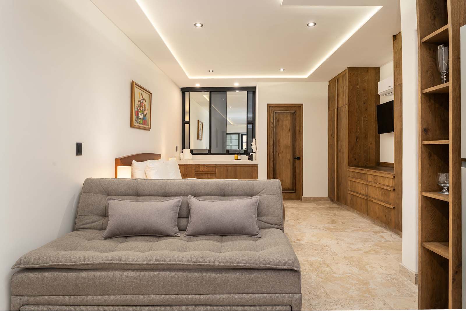 Living area with sofa bed, Smart TV, and wooden cabinetry