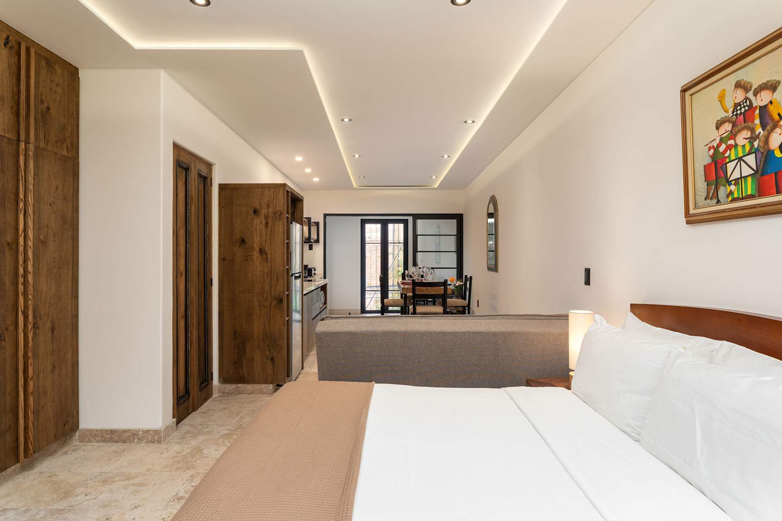 Bedroom with queen bed, open layout, and wooden cabinetry