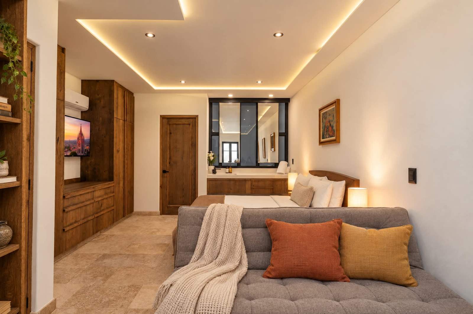 Recámara principal con sofá cama, cama queen y baño privado con acabados modernos