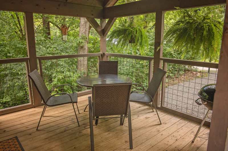 Covered front porch with charcoal grill and outdoor seating