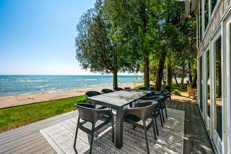 Step outside from the main living room onto this inviting deck, where outdoor dining meets the tranquil beauty of Lake Michigan.