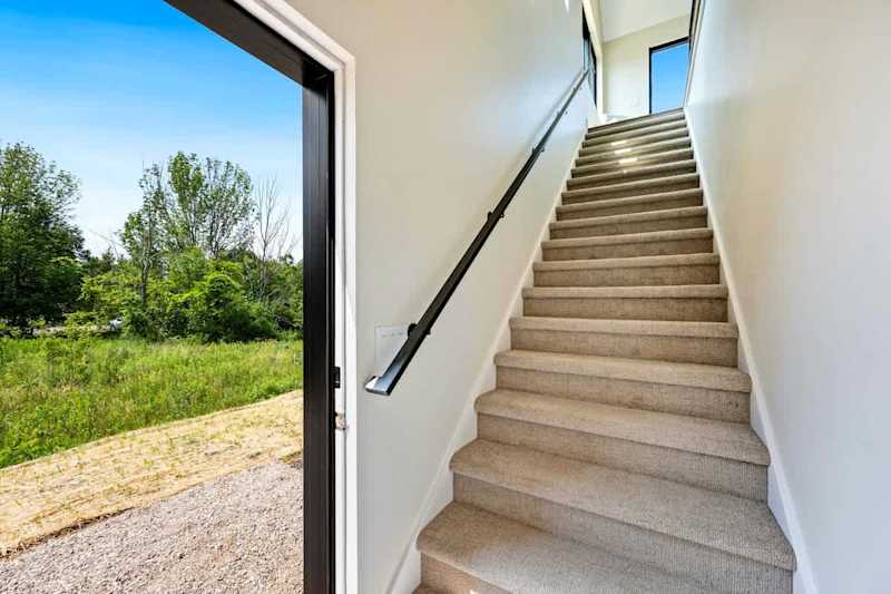 To enter the loft, you will use the side door of the garage and walk up the stairs.