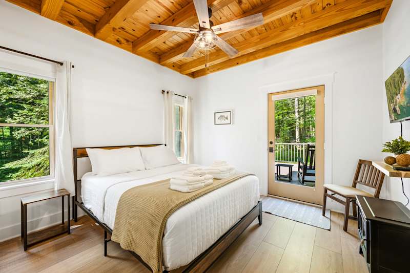 Just off the main living area, the private primary suite offers a comfortable queen bed, TV, cozy fireplace, and an ensuite bathroom complete with a soaking tub and spacious walk-in shower.