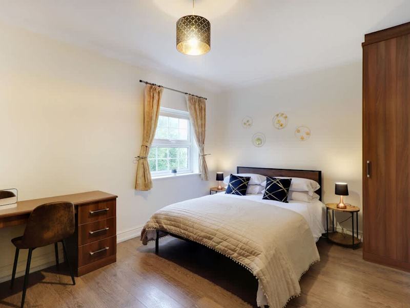A double bedroom made up with fresh linen, with desk space for home working
