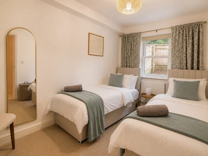 A bedroom made up with fresh linen and towels