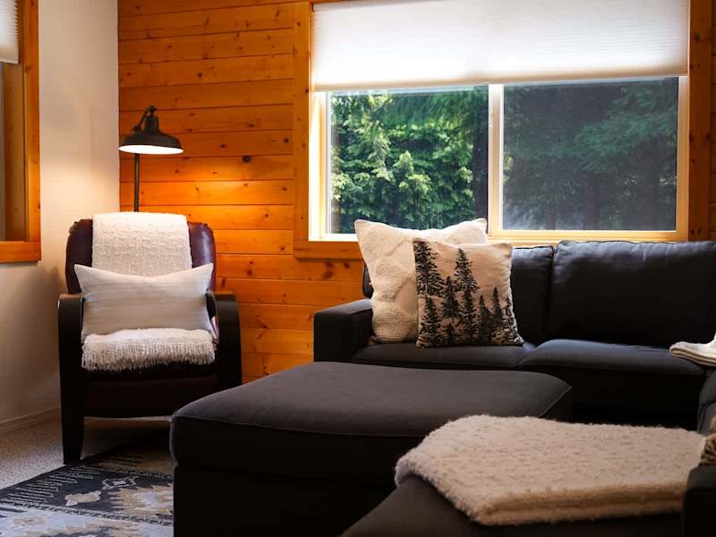 Reading nook in the living room overlooking the forest drenched windows. 