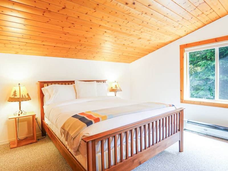 Primary bedroom with queen bed and balcony access. 