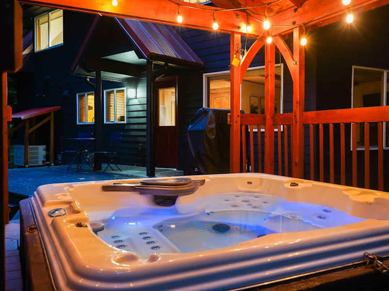 Enjoy a covered hot tub and soak in the beauty of the trees surrounding the home. 