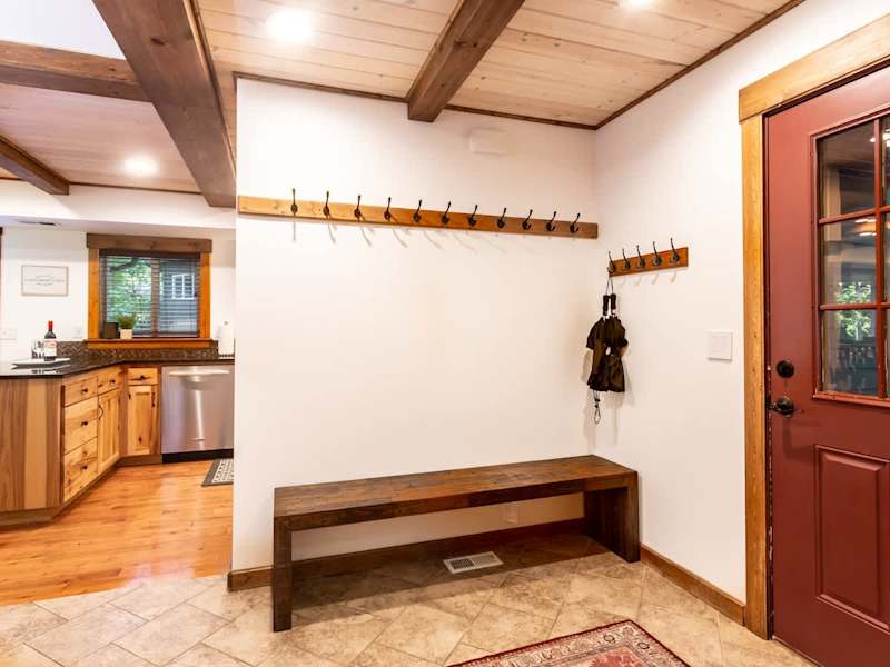 Entryway mudroom with plenty of space for hanging snow or hiking gear, with boot trays and umbrellas. 