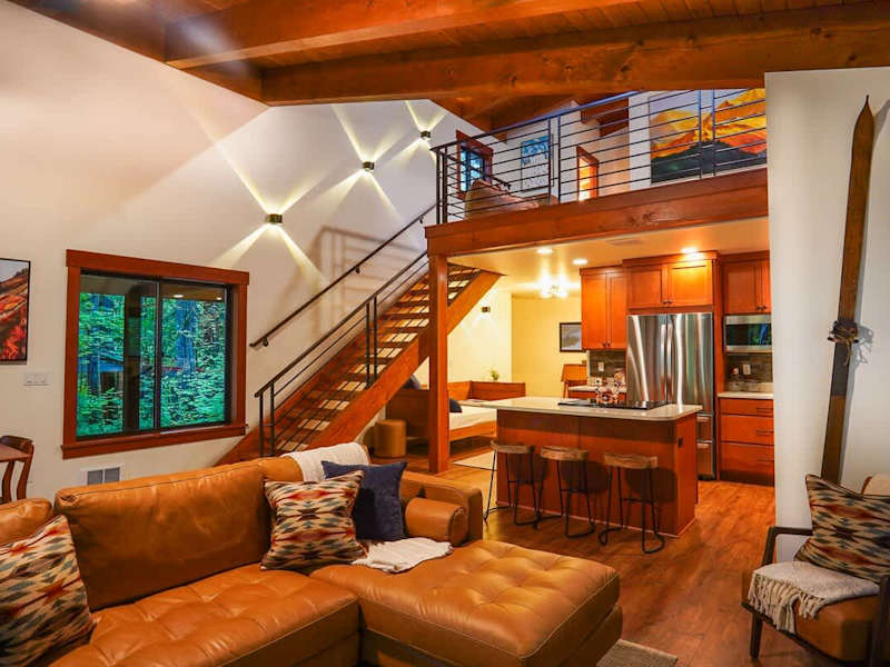 View from the living room towards the full kitchen with the stairs to the loft on the left. 