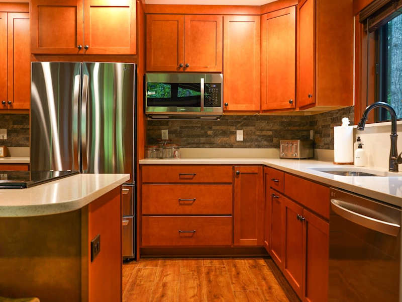 Kitchen with the dishwasher and sink on the right and fridge and stove on the left. 