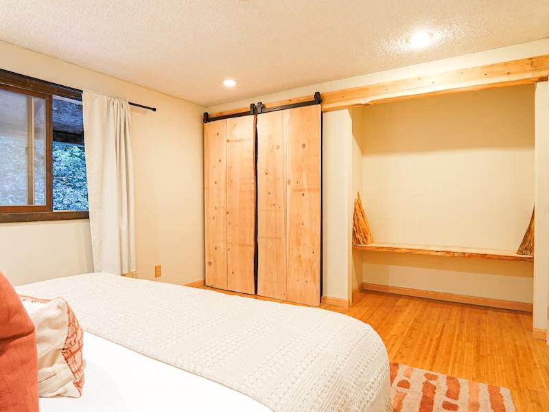 upstairs bedroom with Helix king sized bed and custom wood bench. 