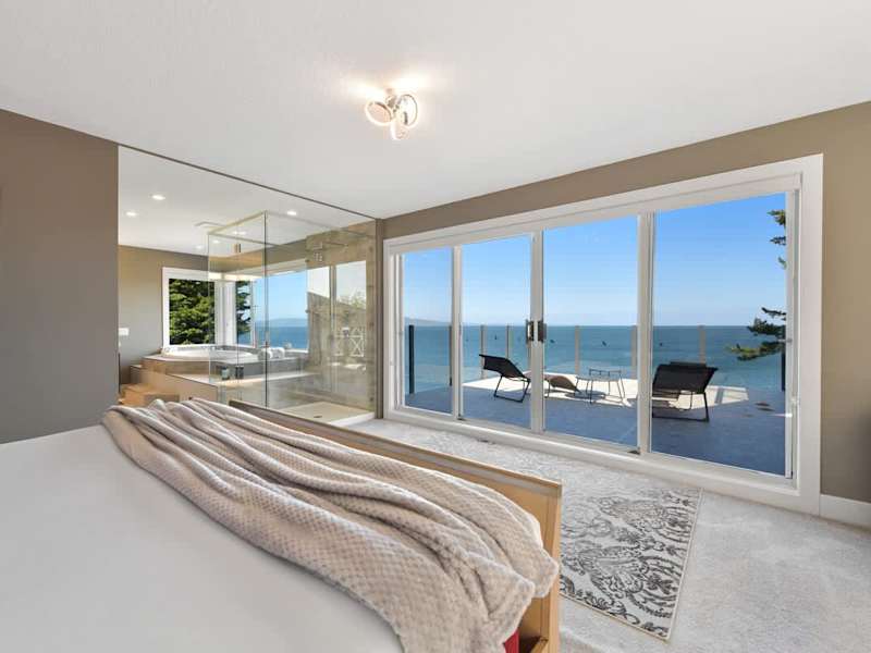 Primary bedroom suite on the top floor with king bed, private deck, living room and full ensuite with walk in closet.