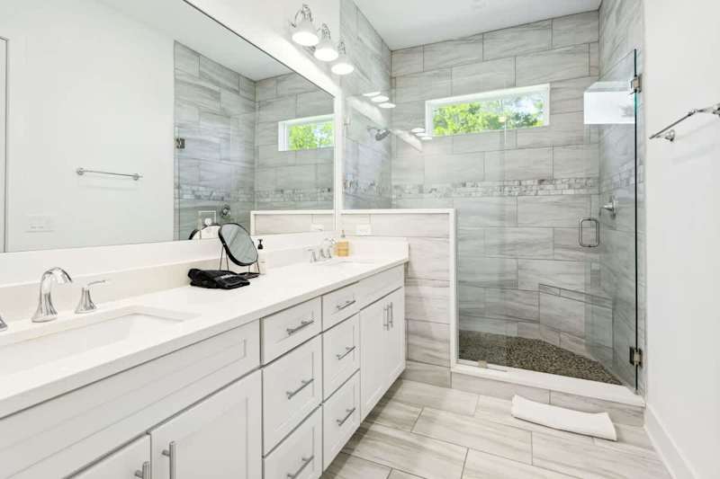 Bathroom has dual sinks and large walk-in shower.