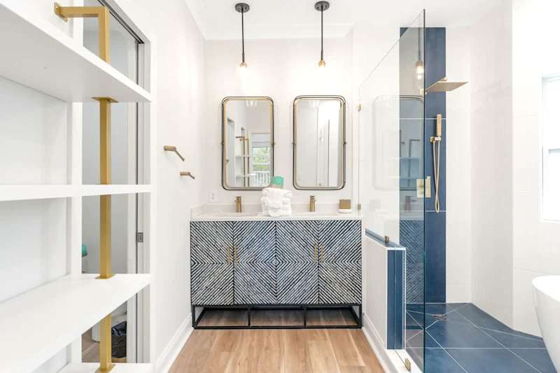 Luxurious primary bathroom with double rainfall showerheads and soaker tub.