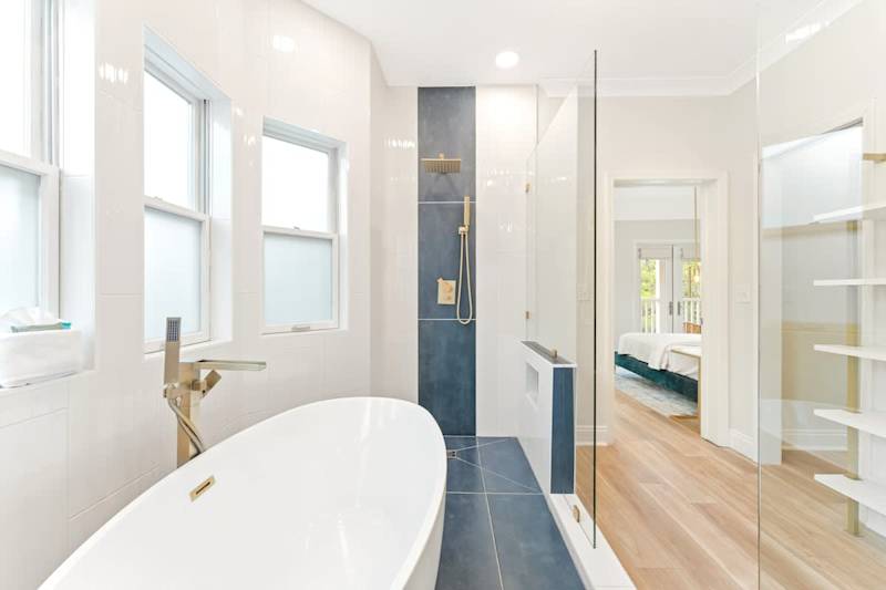 Luxurious primary bathroom with double rainfall showerheads and soaker tub.