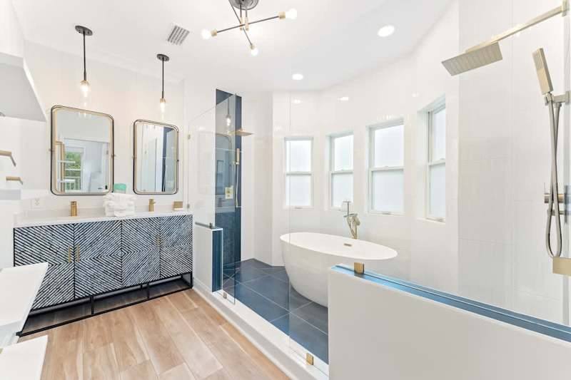 Luxurious primary bathroom with double rainfall showerheads and soaker tub.