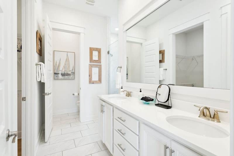 Primary bathroom features double vanities, walk-in closet, and rainfall shower.